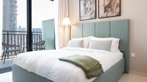 a bedroom with a large bed and a balcony at Keyrock - Zada Tower, Business Bay Lake-View Apartment in Dubai