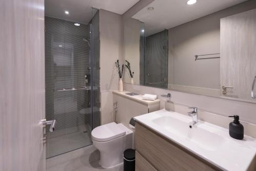 a bathroom with a toilet and a sink and a shower at Keyrock - Zada Tower, Business Bay Lake-View Apartment in Dubai