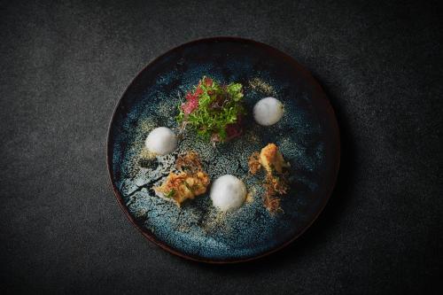 a black plate with food on a table at TAYUTA amakusa in Kami Amakusa