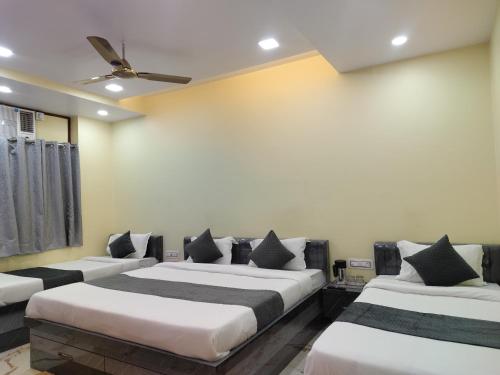 Un dormitorio con dos camas y un ventilador de techo. en Kartikey Home Stay, en Varanasi