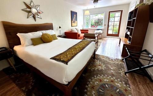 a bedroom with a large bed and a living room at Couples Cottage l Steps to Downtown in Solvang