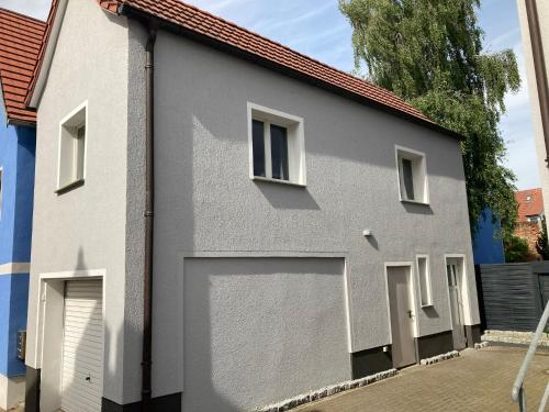 a gray and white building with a garage door at Müritz Apartments in Waren