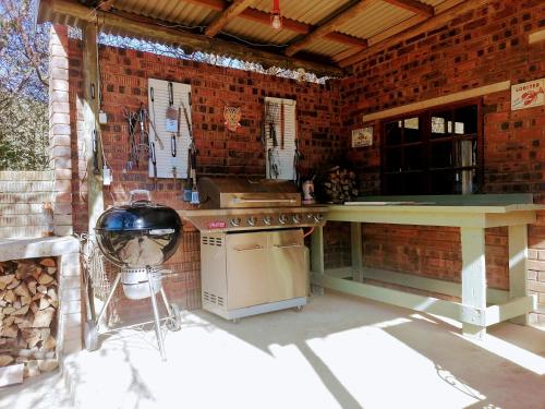 a outdoor kitchen with a counter and a stove at Hawklee Country House in Nottingham Road