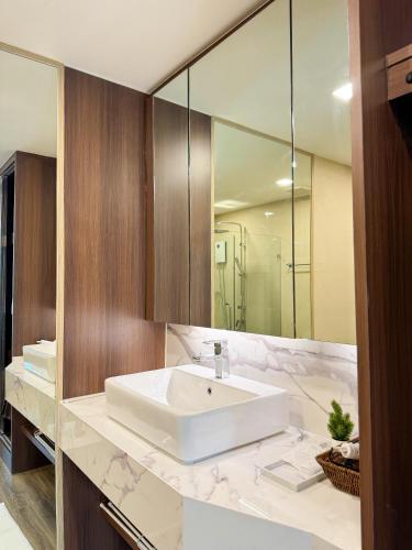 a bathroom with a white sink and a mirror at Forest Khaoyai by Licega in Ban Huai Sok Noi