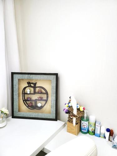 a picture frame sitting on a shelf above a toilet at Wonju Aunt Home in Wonju