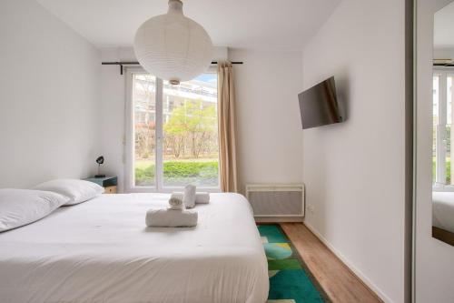 une chambre avec un grand lit blanc et une fenêtre dans l'établissement LE MAILLE- T2 au calme en centre-ville, à Nantes