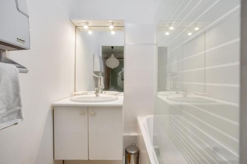 La salle de bains blanche est pourvue de 2 lavabos et d'une baignoire. dans l'établissement LE MAILLE- T2 au calme en centre-ville, à Nantes