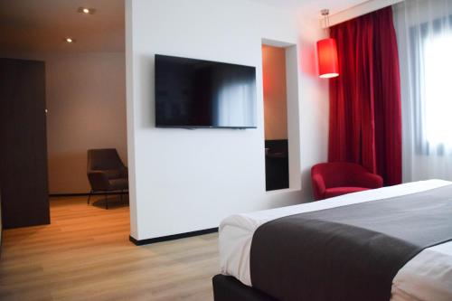 a hotel room with a bed and a flat screen tv at Bastion Hotel Amersfoort in Amersfoort