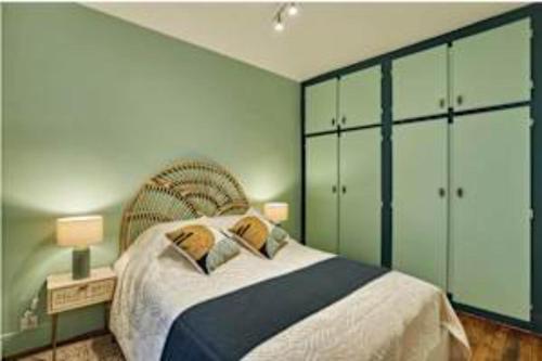 - une chambre avec un grand lit et des armoires vertes dans l'établissement Superb Apartment Le Marais Place des Vosges, à Paris