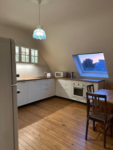 Il comprend une cuisine avec des placards blancs, une table et une télévision. dans l'établissement Great Accommodation Colmar Free Parking, à Colmar