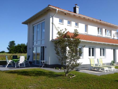 a white house with chairs and a table at Villa Kiek Ut in Trent
