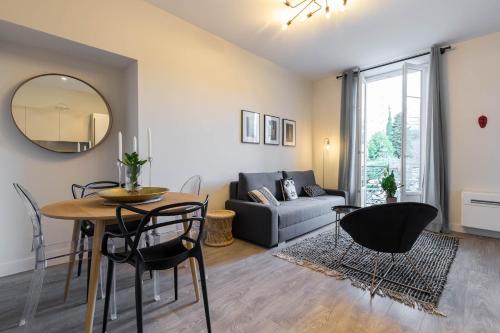 un salon avec une table, des chaises et un canapé dans l'établissement T2 neuf Clim Balcon Garibaldi Acropolis, à Nice