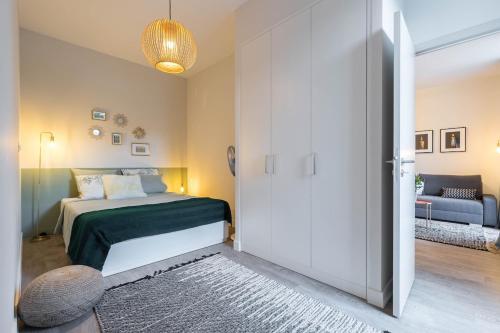 - une chambre avec un lit et une porte avec un canapé dans l'établissement T2 neuf Clim Balcon Garibaldi Acropolis, à Nice