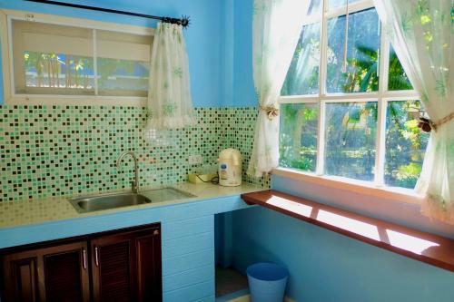 a kitchen with a sink and a window at Baan Sarika Phusuan in Nakhon Nayok
