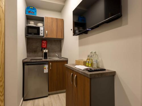 a small kitchen with a sink and a microwave at Piccolin Studios by GB Apts in Valletta