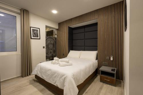a bedroom with a large bed with white sheets at Piccolin Studios by GB Apts in Valletta