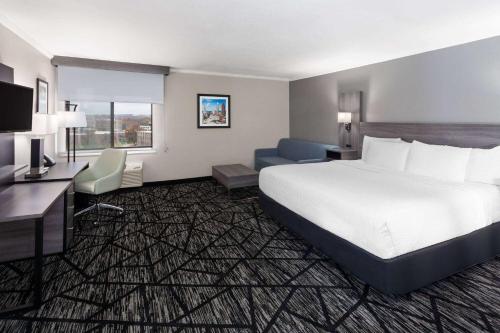 a hotel room with a large bed and a desk at La Quinta Inn by Wyndham Cleveland Independence in Independence