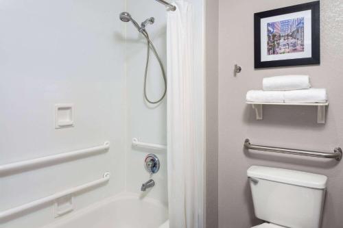 a bathroom with a white toilet and a shower at La Quinta Inn by Wyndham Cleveland Independence in Independence