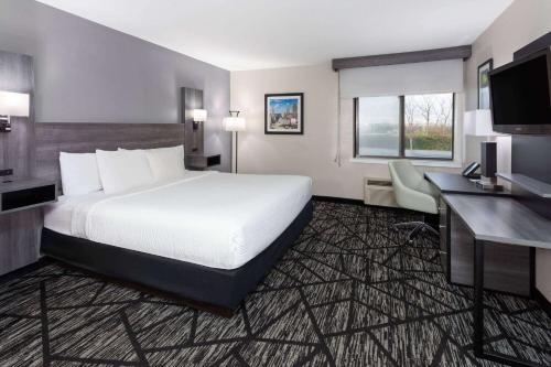 a hotel room with a large bed and a desk at La Quinta Inn by Wyndham Cleveland Independence in Independence