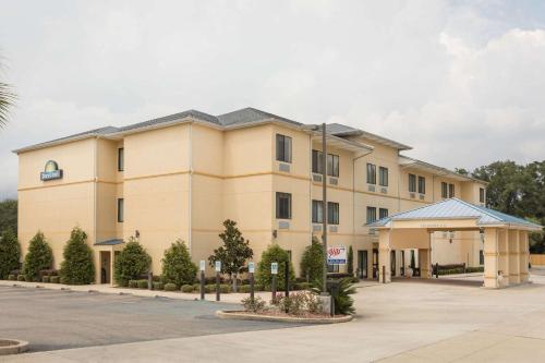 a large tan building with a parking lot at Days Inn by Wyndham Semmes Mobile in Mobile