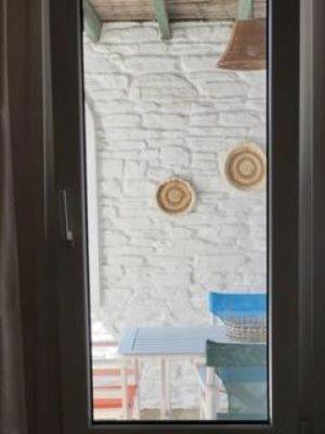 a glass door with a table in a room at Andros Eco Home in Gavrion