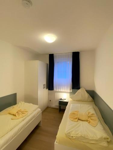 two beds in a small room with a window at Fewo 4 in Willingen