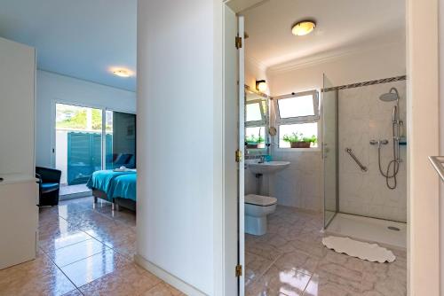 a bathroom with a shower and a toilet and a sink at Casa Flora, 2 quartos,vista mar in Arco da Calheta