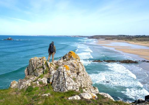 Un homme debout sur un rocher surplombant l'océan dans l'établissement Gîte entre Paimpol Bréhat et Perros Guirec Côte de Granit Rose Vue terre mer, à Plouguiel