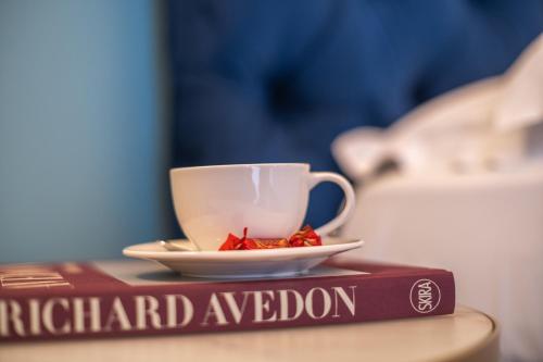 a book with a cup of tea on top of it at Family Affair Luxury Rooms&Suites in Palermo