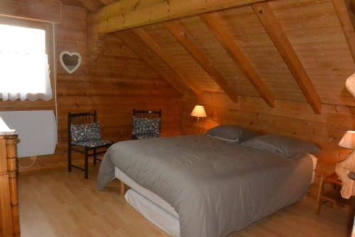 a bedroom with a bed in a log cabin at Chalet sous Le Théâtre in Bussang