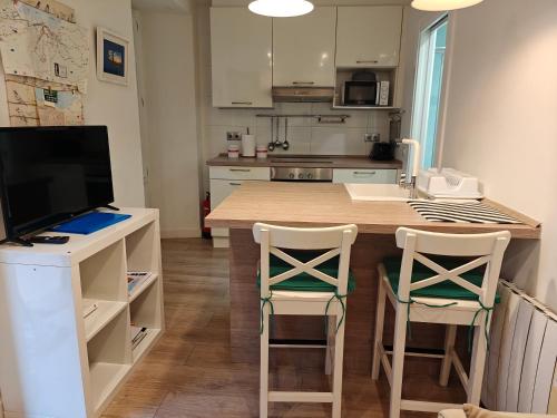 une cuisine avec une table en bois et deux chaises dans l'établissement Vicaria, à Gijón