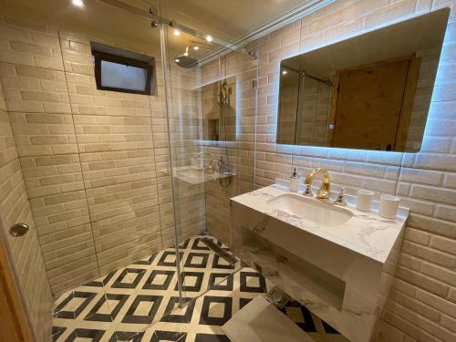 a bathroom with a sink and a mirror at Bella Guesthouse with Garden, Pool & Jacuzzi in Kafr ‘Ubaydā