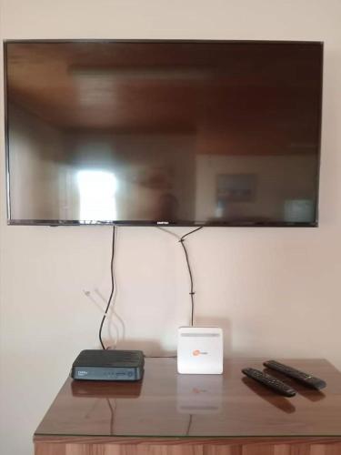 a television on top of a table with two remote controls at Paresis 7 in Hentiesbaai