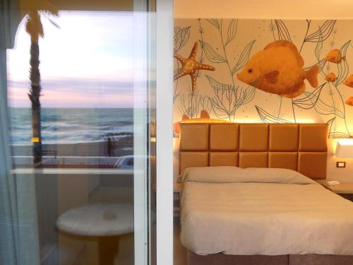 a bedroom with a bed with a fish mural on the wall at Hotel Kaly in Ventimiglia
