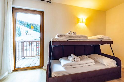 a bunk bed in a room with a window at Hotel Grizzly "Ski-in Ski-out" in Folgaria