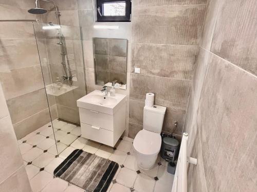 a bathroom with a toilet and a shower and a sink at Aquamarine House in Balchik