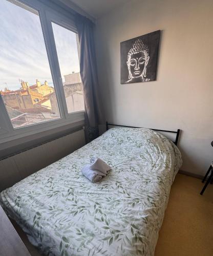 un lit dans une chambre avec une grande fenêtre dans l'établissement Studio au coeur de Valence 25, à Valence