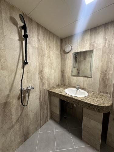 a bathroom with a sink and a shower at Хотел Костенец in Kostenets