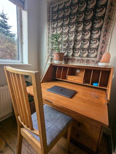 a wooden desk with a laptop on top of it at Cosy home in Chapel Allerton Area - Peaceful Street, Free Parking in Leeds