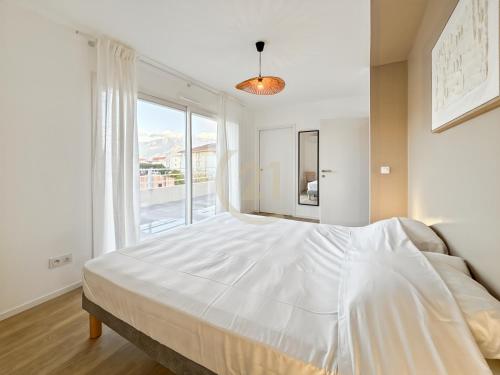 un grand lit blanc dans une chambre avec une fenêtre dans l'établissement Duplex T4 proche de la plage à Calvi, à Calvi