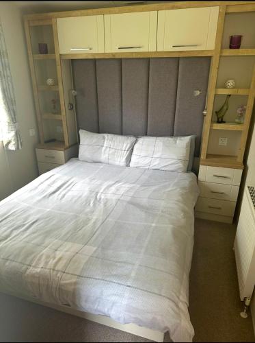 a bedroom with a large bed with white sheets at The Meadows in Tattershall