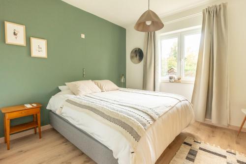 a bedroom with a bed with a green wall at Le cocon du Duc in Namur
