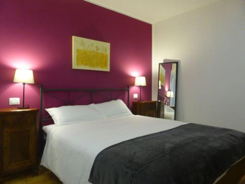 a bedroom with a large bed with purple walls at La Valeriana Farm Apartments in San Daniele del Friuli