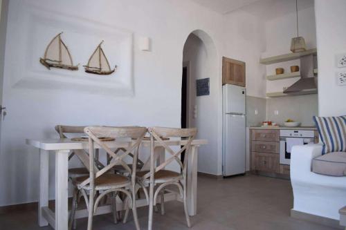 a kitchen with a table and chairs in a room at Astypalaia Bella Vista Houses Blue, Verde, Veranda Sunset in Astypalaia Town
