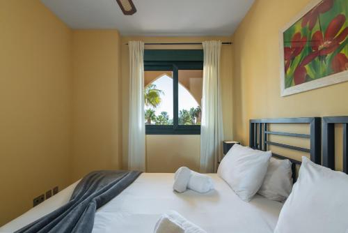 Schlafzimmer mit einem Bett und einem Fenster in der Unterkunft Playa Marina by Ĥ - Playa Punta del Moral PPHM319P74 in Punta del moral