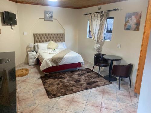 Un dormitorio con una cama y una mesa y sillas. en SABATH LODGE, en Ciudad del Cabo