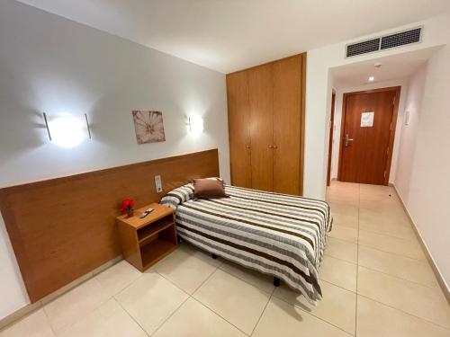 a bedroom with a bed and a table in a room at Hotel Avenida El Morell in El Morell