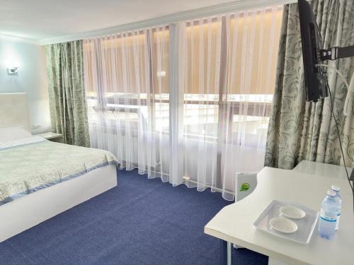 a hotel room with a bed and a window at Байтерек рядом Министерство in Astana