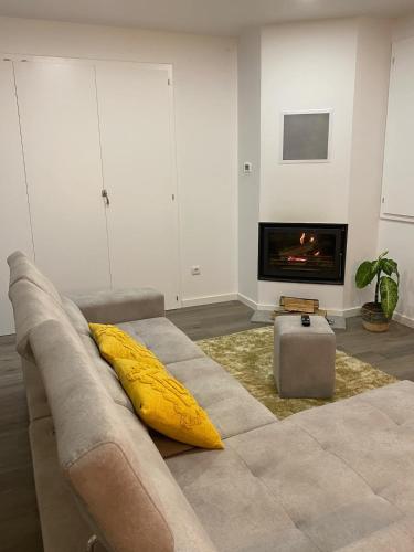 a living room with a couch with a yellow pillow at casa de campo in Virtelo