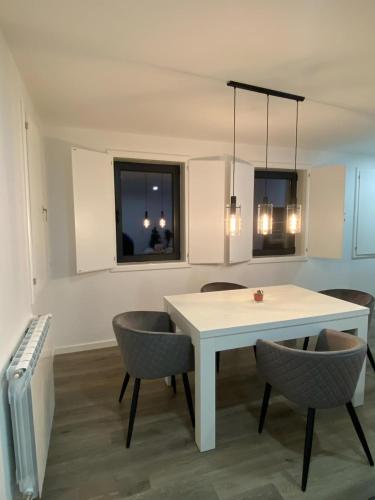 a dining room with a white table and chairs at casa de campo in Virtelo